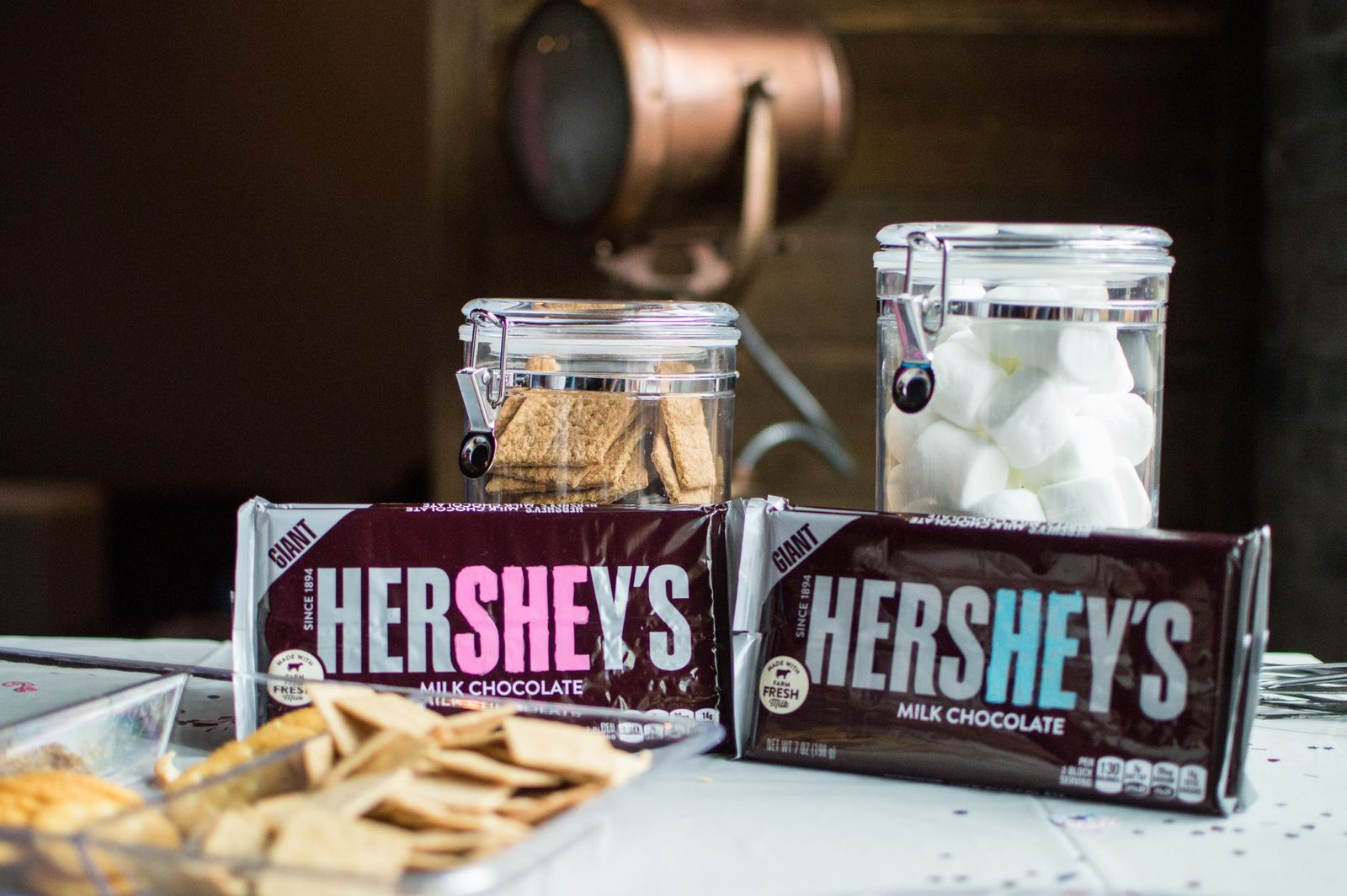 Close-up of Hershey's chocolate bars with jars of graham crackers and marshmallows for delicious s'mores.