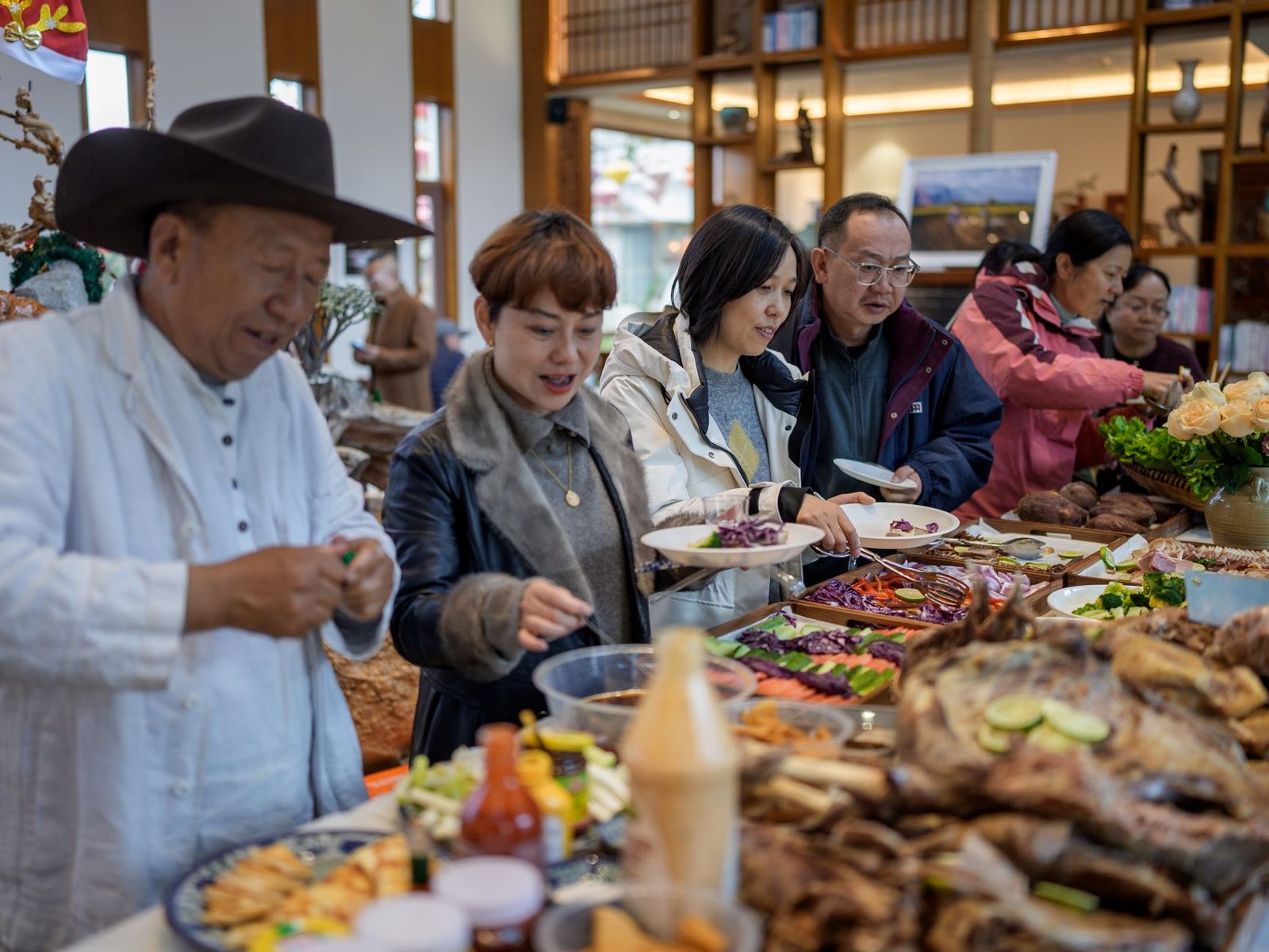 A diverse group of adults selecting food at an indoor buffet. Vibrant and lively atmosphere.